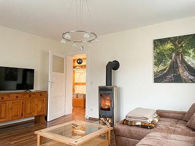 Wohnzimmer mit SmartTV, Kaminofen und  Schlafsofa
