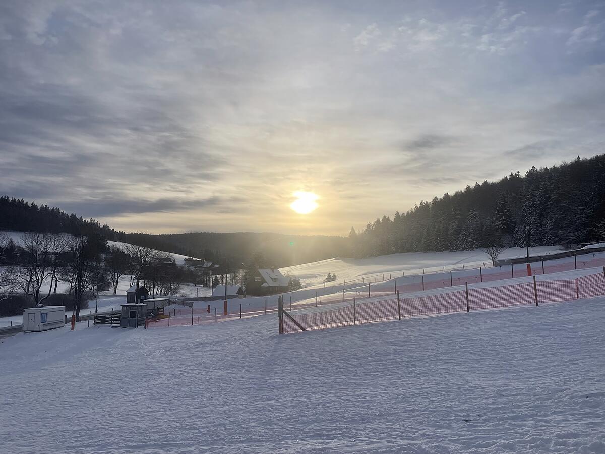 Sonnenaufgang über der Winterlandschaft am Skihang